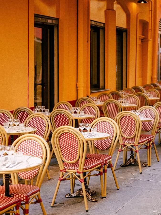 La terrasse du Bouillon Saleya, chaises cannées rouges et tables dressées devant la façade ocre